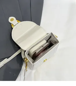 Detail view of the spacious white woven leather bag interior holding a smartphone