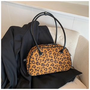 Detailansicht einer Boston-Tasche mit Leopardenmuster und schwarzen Ledergriffen