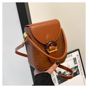 Detail of caramel brown mini bag featuring woven texture and vintage round buckle clasp