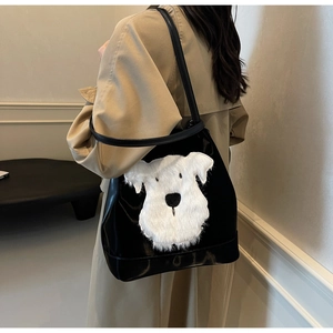 Vue détaillée d'un sac cabas en cuir noir orné d'un écusson de chiot en peluche doux