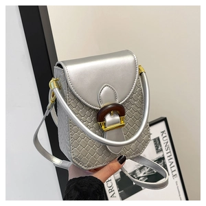 Close-up of silver textured mini bag with gold hardware and wood-style clasp detail