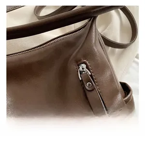 Close-up of premium silver hardware zipper on a vintage brown leather tote bag