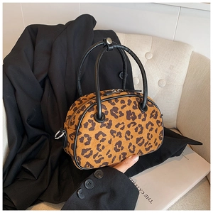 Detail der Leopard-Handtasche auf einem weißen Sessel mit einem schwarzen Sakko daneben