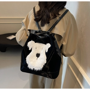 Détail d'un sac à dos noir brillant à cordon avec un patch en peluche de schnauzer