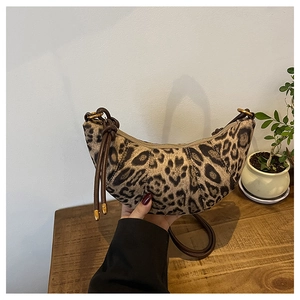 Dettaglio della borsa a mezzaluna leopardata con finiture in metallo e tracolla sottile