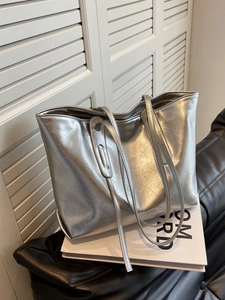 Silver metallic tote bag with pleated texture and large capacity on white minimal background