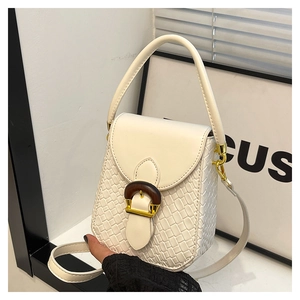 Detail of cream white crossbody bag featuring woven texture and wooden ring buckle