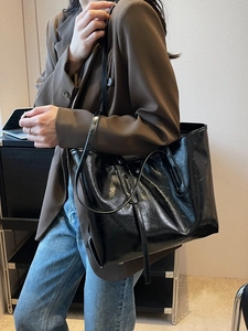 Large capacity black oil wax leather tote bag shown on model with casual brown blazer