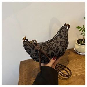 Dettaglio della borsa a mezzaluna leopardata con tracolla sottile e forma a croissant