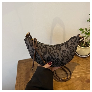 Dettaglio della borsa a mezzaluna leopardata con tracolla in pelle marrone e zip dorata