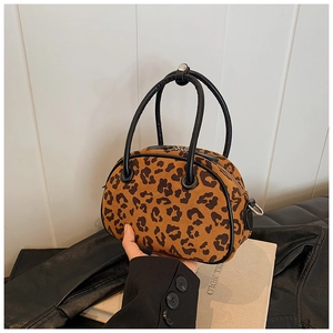Detailaufnahme der Leoparden-Bowling-Handtasche mit schwarzen Griffen und Reißverschluss
