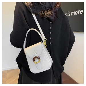 Detail of white crossbody bag with crocodile texture and decorative wood-pattern U-buckle