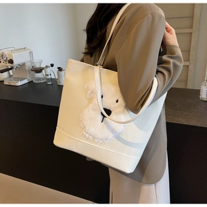 Détail du sac cabas en cuir PU blanc avec écusson chien en peluche porté par mannequin