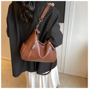 Brown vintage hobo bag shown from back view on model with wide adjustable shoulder strap