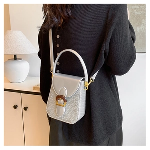 Detailed macro view of silver crocodile pattern mini crossbody bag with wooden buckle accent