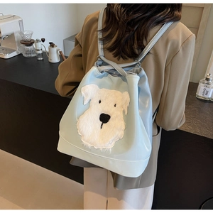 Détail du sac à dos en cuir PU bleu clair avec un appliqué de chiot en peluche 3D