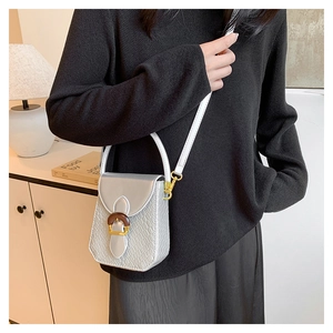 Silver crocodile embossed crossbody bag with wood-style clasp shown on a model