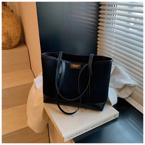 Close-up of black matte tote bag with LUOMEINISHA metallic logo and textured straps