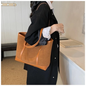 Detail of camel suede and leather tote bag showing high-capacity design and shoulder strap