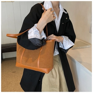 Detail view of brown suede and leather tote bag showing material textures and stitching