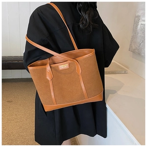 Detail of vintage brown tote bag with textured matte and smooth synthetic leather stitching