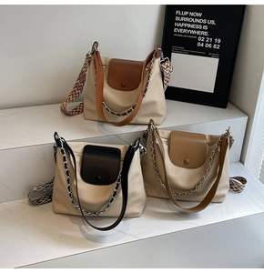 Detail view of canvas tote bags with leather trim and ethnic jacquard strap in 45-degree angle