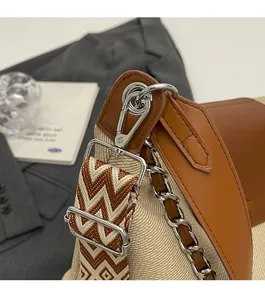 Detail of silver hardware buckle and wide jacquard woven shoulder strap on a tote bag