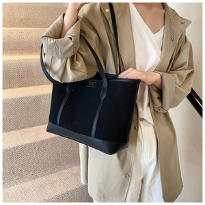 Detail view of retro matte black tote bag with canvas and leather patchwork textures