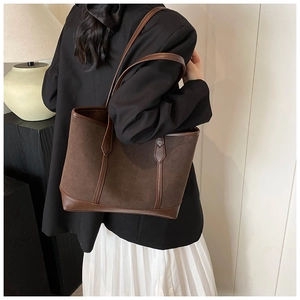 Detail of vintage matte tote bag showing suede texture and smooth leather trim detail