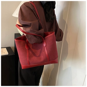 Detail of burgundy tote bag showing mixed matte suede and smooth leather texture with straps
