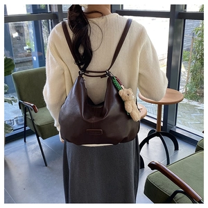 Detailed view of dark brown hobo bag with teddy bear charm and soft matte finish
