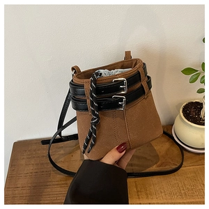 Détail d'un sac seau marron mat avec lanières noires et fermeture par cordon