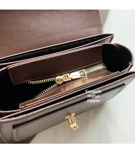 Détail de l'intérieur du sac en cuir marron avec fermeture éclair dorée fluide