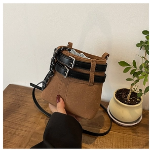 Sac seau en cuir mat marron avec lanières noires décoratives et boucles métalliques