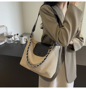 Detail of khaki canvas and black leather patchwork tote with silver chain shoulder strap