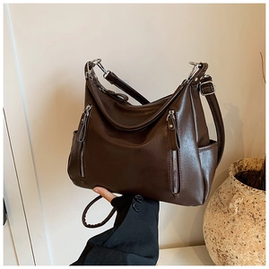 Detail of soft dark brown PU leather tote with vertical zip pockets and adjustable strap