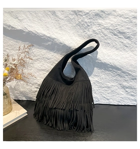 Detailansicht der Fransen und der mattschwarzen Wildledertextur der Vintage Tasche