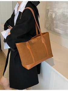 Vintage matte brown tote bag with suede texture shown on shoulder of a female model