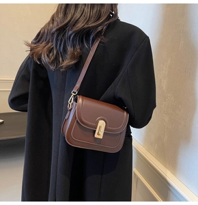 Vue détaillée du sac bandoulière en cuir marron avec rabat vintage et fermoir doré