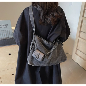Mannequin avec grand sac cabas en jean gris foncé, bandoulière chaîne et pochette