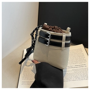 Détail du sac seau crème avec ceintures noires et doublure à cordon marron