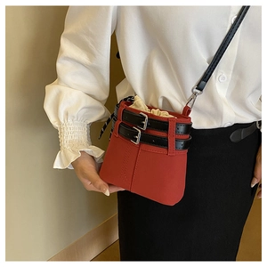 Détail du sac seau rouge à cordon avec lanières en cuir noir et boucle argentée