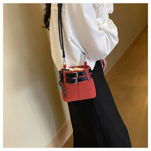 Mini sac seau rouge avec sangles à boucle noire et doublure en tissu porté en bandoulière