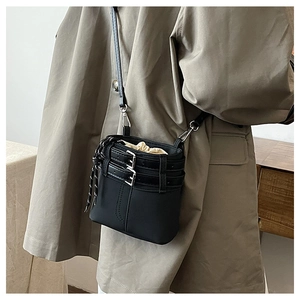 Détail du sac seau noir avec cordon de serrage et ceinture à boucles en métal