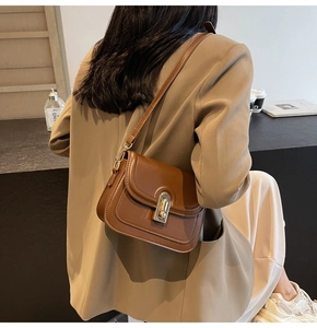 Vue détaillée d'un sac à bandoulière marron vintage avec fermoir rotatif doré élégant