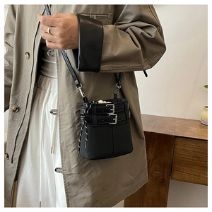 Détail d'un mini sac seau noir avec boucles en métal argenté et cordon de serrage rayé