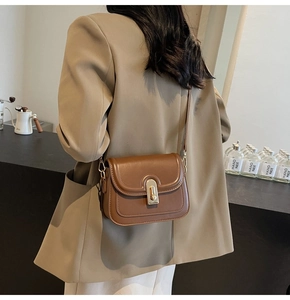 Sac à bandoulière marron caramel porté avec un blazer beige pour un look sophistiqué