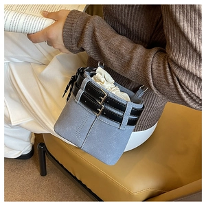 Détail du sac seau bleu clair en daim avec doubles boucles noires et cordon de serrage