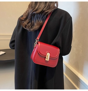 Détail du sac bandoulière tendance en cuir rouge avec fermoir métallique doré