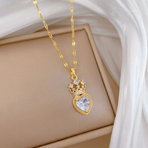 Macro view of crystal heart pendant with gold crown on flat chain and jewelry box